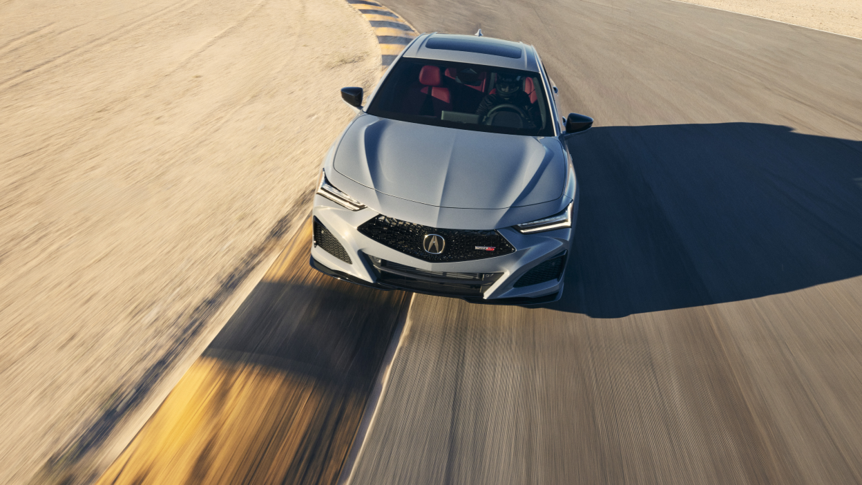 3/4 front bird’s eye view of grey TLX Type S taking turn on desert racetrack.