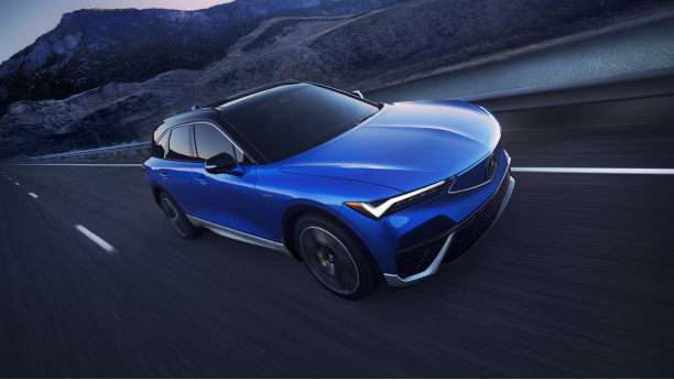 3/4 bird’s eye front view of blue ZDX driving on desert highway at dusk.