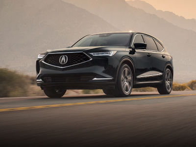 An Acura MDX barreling down the highway in the dessert as the background scenery is blurry. // Un Acura MDX dévalant l'autoroute dans le désert alors que le paysage d'arrière-plan est flou.
